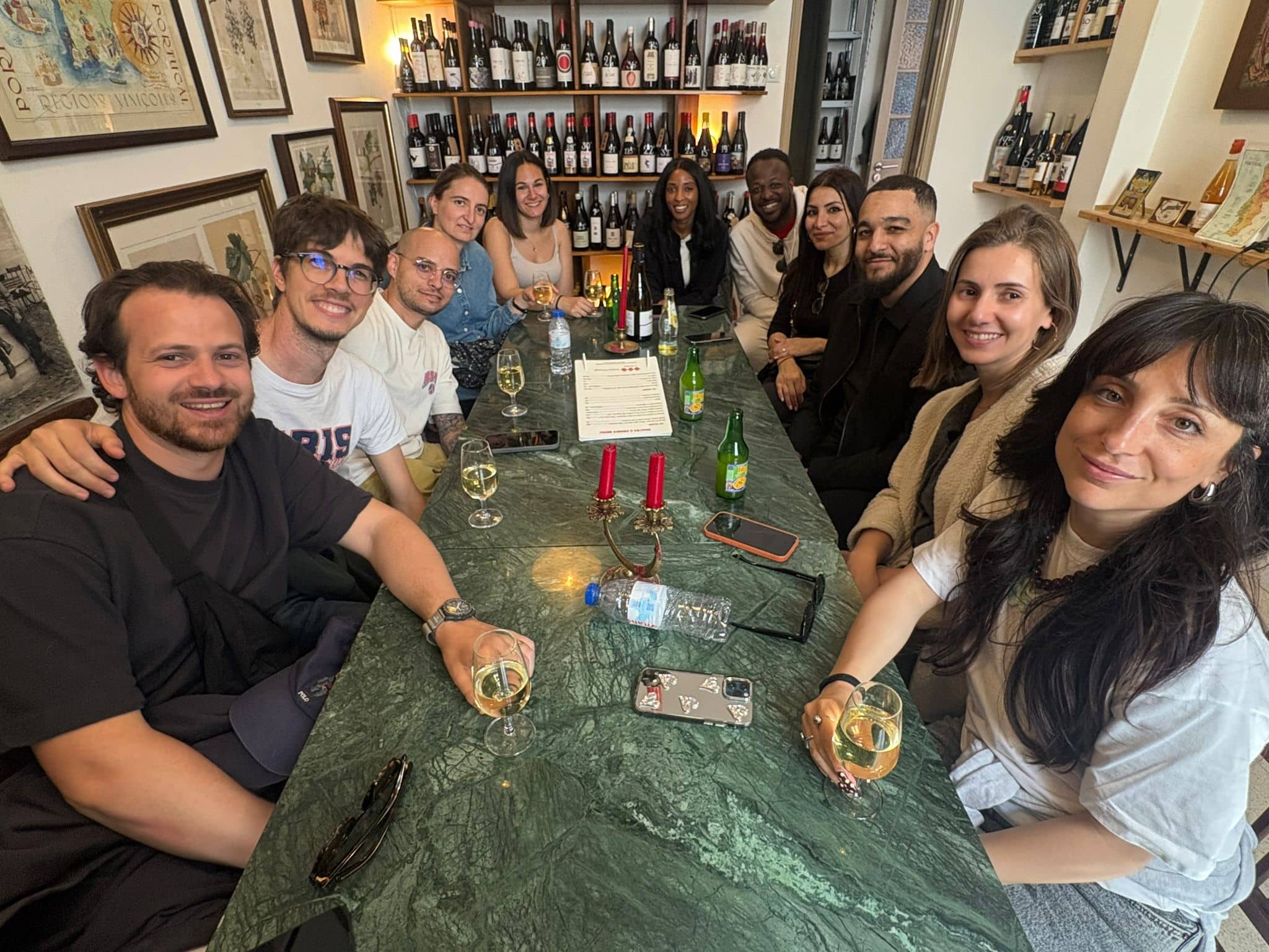 Friends tasting Portuguese wines around the marble table at POP, Graça, Lisbon
